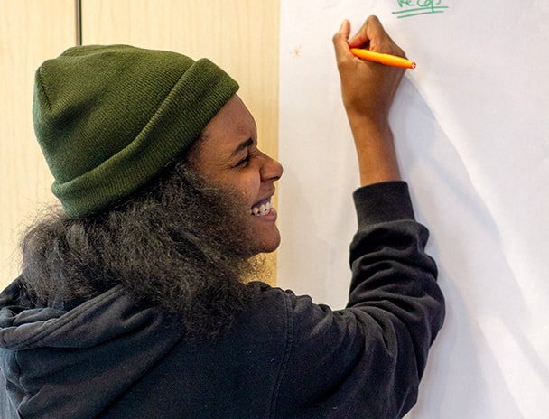 Woman smiling in front of a whiteboard